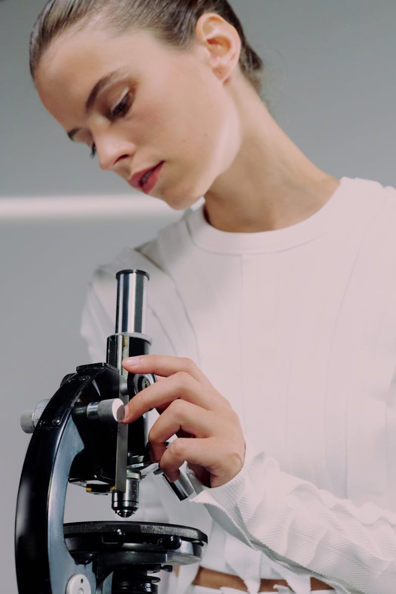 Close-up of a female scientist researching with a microscope in a laboratory setting.