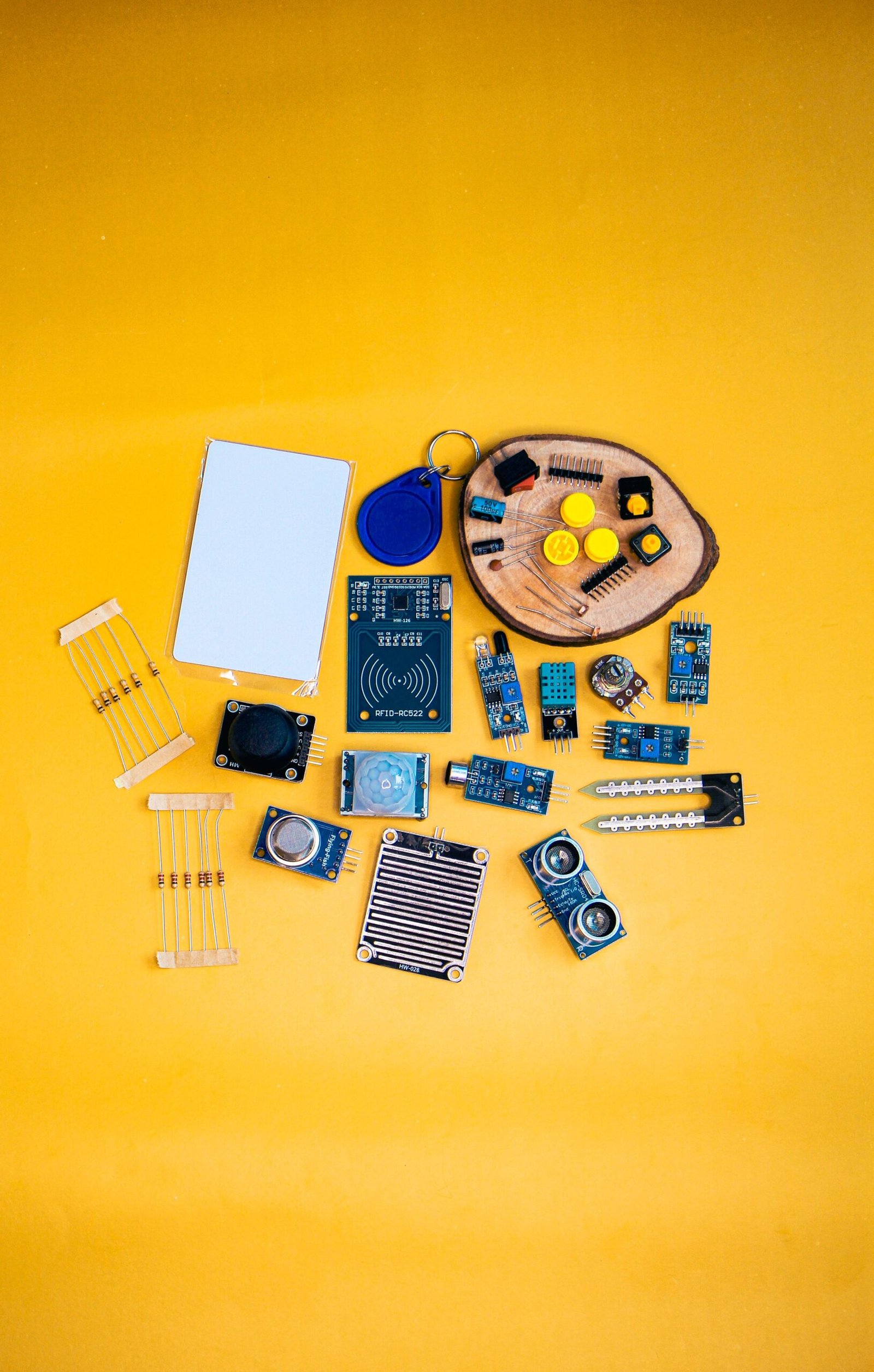 A collection of electronic components arranged on a vibrant yellow surface, ideal for tech enthusiasts.